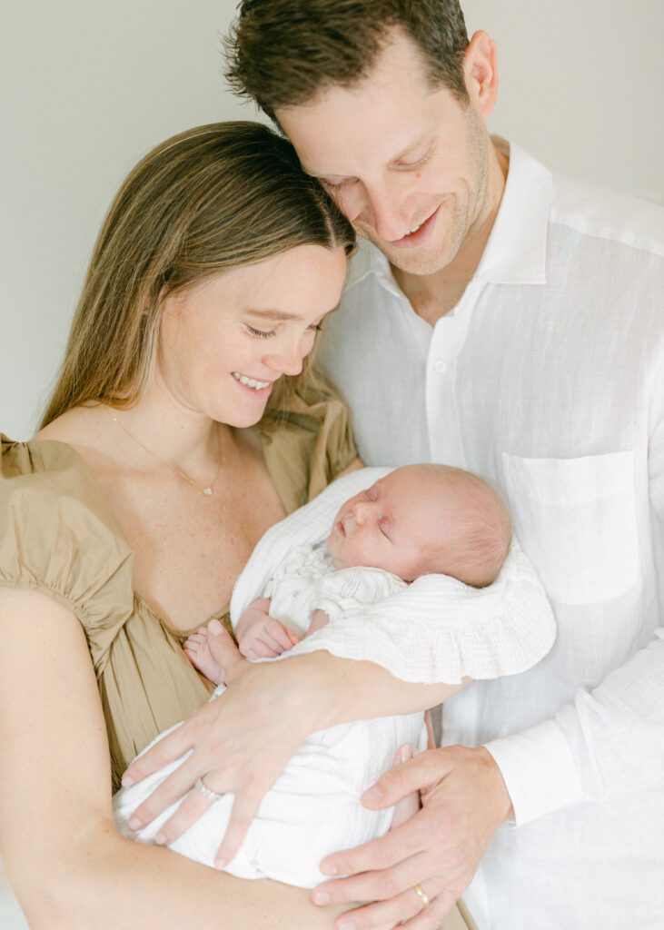 Mom and dad holding a newborn baby. Photo by Denver photographer Maegan R Photography